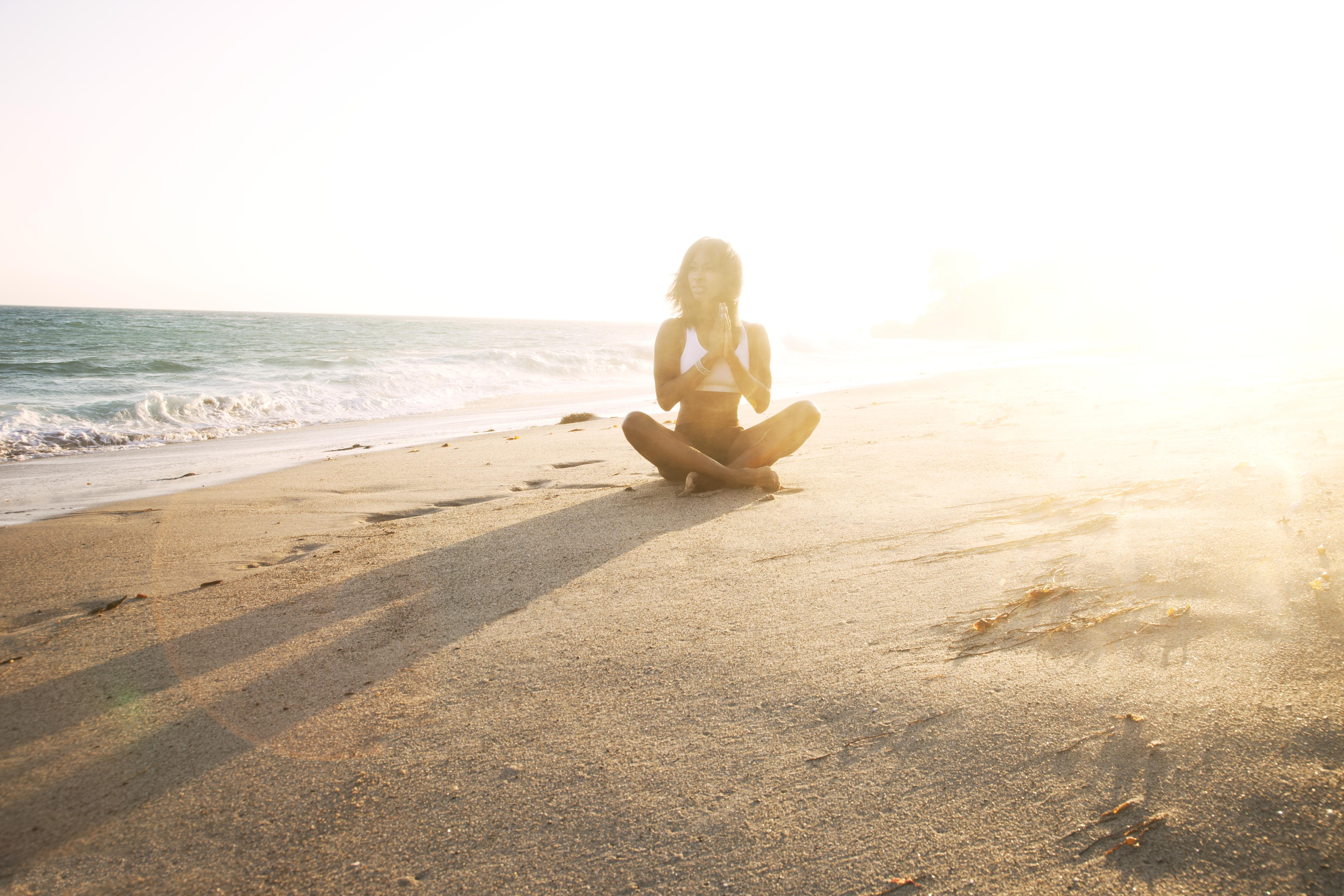 girl doing yoga on beach