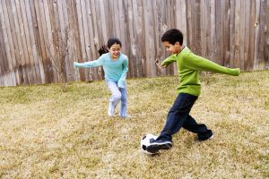 Children ( 8-11) playing football in ground