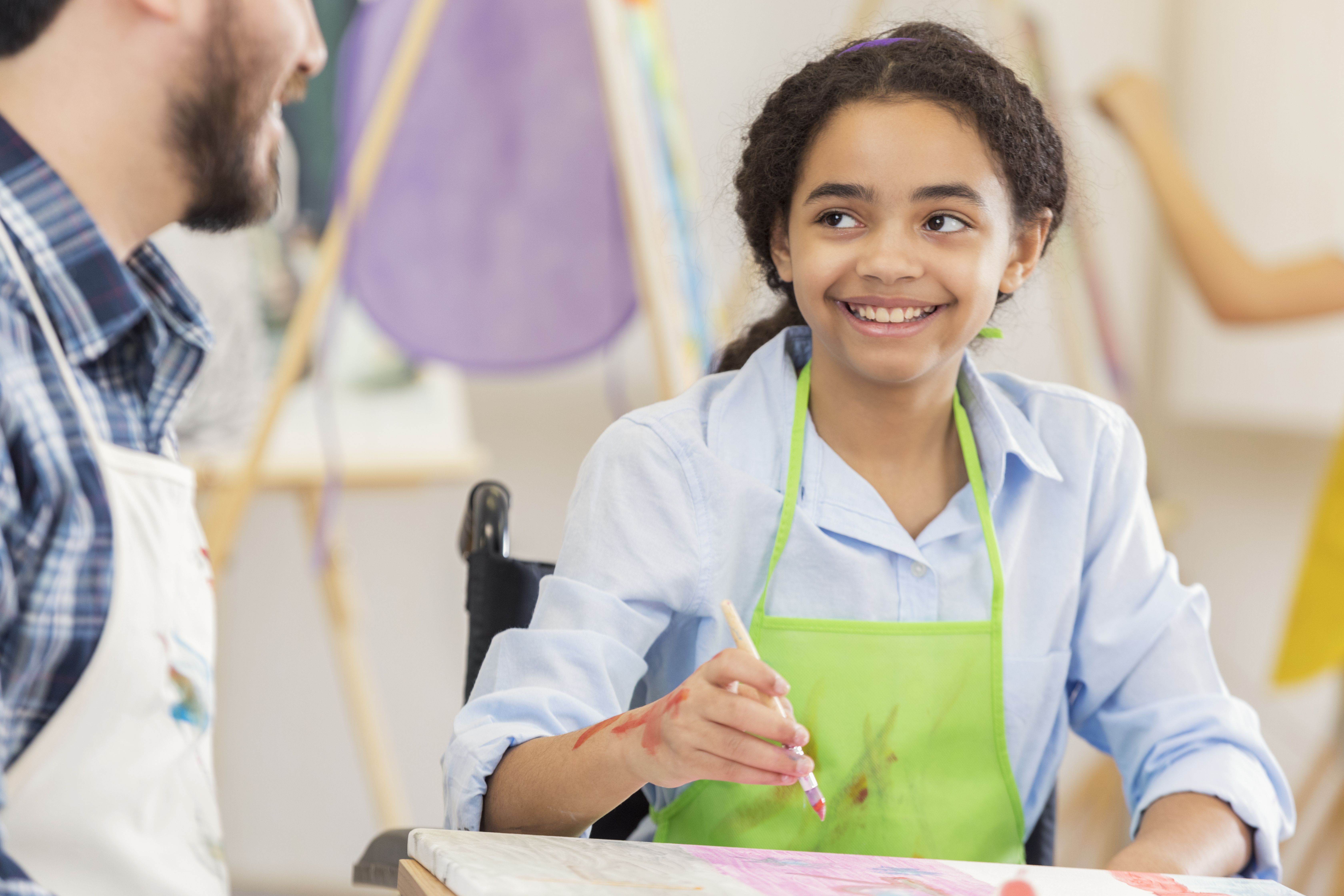 Art teacher works with preteen student