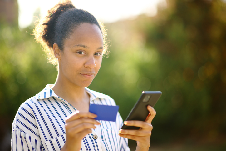Serious black woman buying online looking at camera