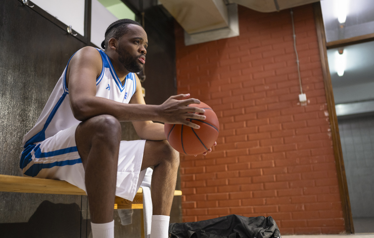 Male Basketball Star With Basketball In Locker Room